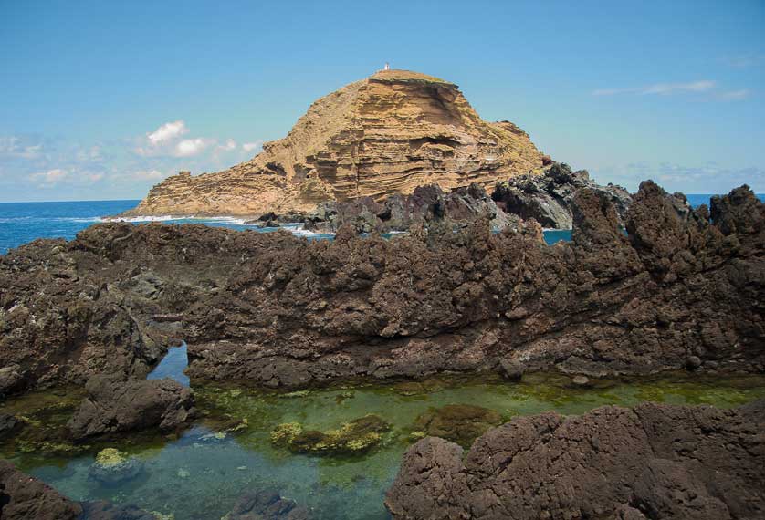 A view of the natural lava pools and the islet of Ilhéu Mole.